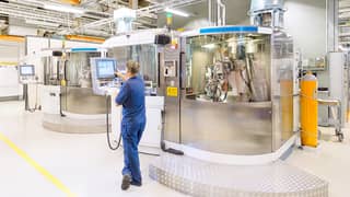 A man monitoring the production in a plant for the manufacturing of inserts.