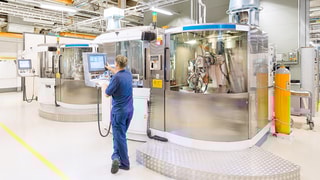 A man monitoring the production in a plant for the manufacturing of inserts.