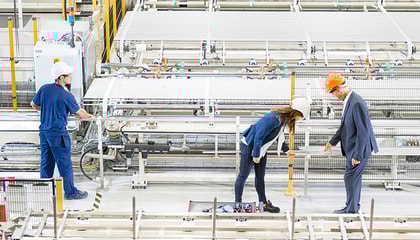 Three persons in a tube mill.