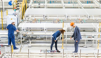 Three persons in factory.