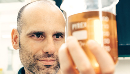 Andrea Azzolini holding a cup of vegetable oil.