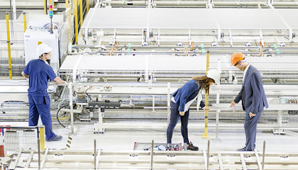 Three persons in a tube mill.